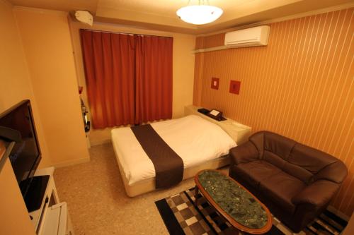 a hotel room with a bed and a couch at Hotel Sindbad Hirosaki-Adult Only in Hirosaki