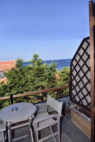 a table and chairs on a balcony with the ocean at Olive Press Hotel in Mithymna
