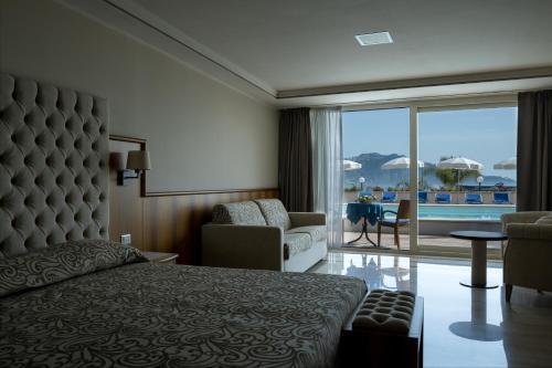 sypialnia z łóżkiem i widokiem na basen w obiekcie Hotel Panoramic w mieście Giardini Naxos