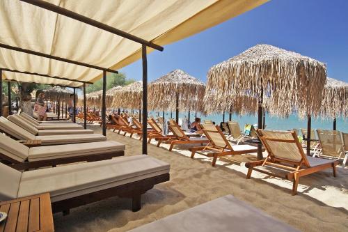 a group of chairs and umbrellas on a beach at FunBeach Rooms in Neos Marmaras