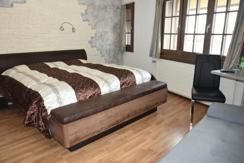 アインジーデルンにあるHotel Sonneのベッドルーム(大型ベッド1台、椅子付)