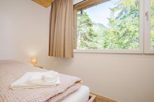 a bedroom with a bed and a window at Sport- und Ferienhaus Don Bosco in Lenzerheide