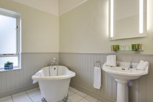 a white bathroom with a sink and a toilet at Sudbury House in Faringdon