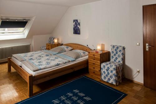 1 dormitorio con 1 cama grande y 1 silla en Gästehaus Tannenhof, en Bad Bergzabern