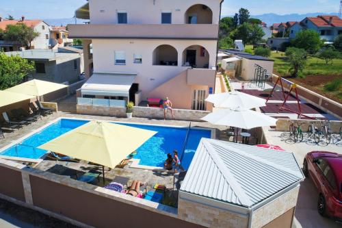 uma vista superior de uma piscina com guarda-sóis em Apartments Julijana em Privlaka