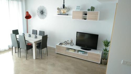 une salle à manger blanche avec une table et une télévision dans l'établissement Casa Gran mirador, 200 m2 ,Vistas al mar y WiFi, PEÑISCOLA, à Peñíscola