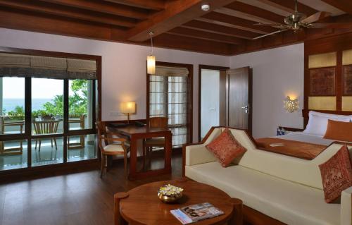 a bedroom with a bed and a living room with a table at Getaway Beach Resort Kovalam in Kovalam