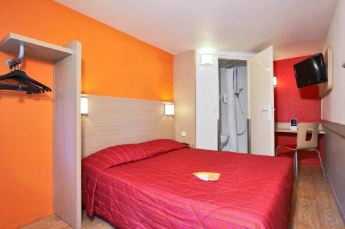 a bedroom with a red bed with a red blanket at Premiere Classe Lille Nord - Tourcoing in Tourcoing