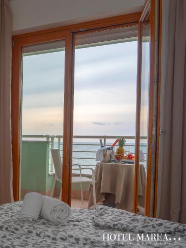 a room with a bed and a view of the ocean at Hotel Marea in Grado