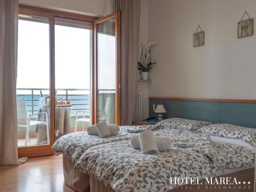 a bedroom with a bed with two pillows on it at Hotel Marea in Grado