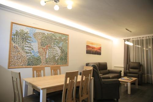 un comedor con mesa, sillas y una pintura en APARTAMENTOS LA VEREDA, en Cuenca