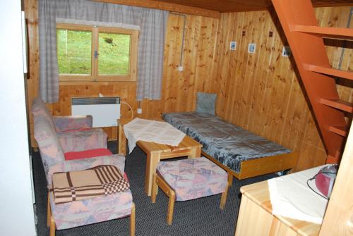 Zimmer mit einem Bett, einem Sofa und einem Stuhl in der Unterkunft Chata Brestová,Zuberec in Zuberec