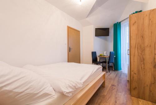 a bedroom with a white bed and a table at Willa Nova in Polańczyk