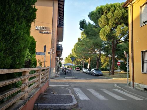 a street with cars parked on the side of a building at Motel Villaggio in Imola