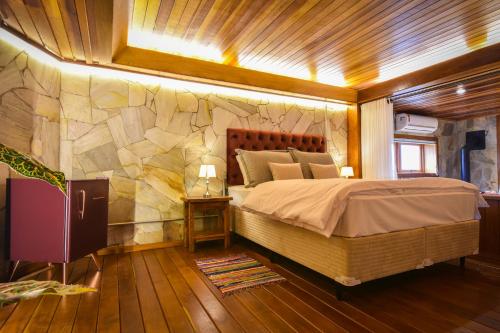 a bedroom with a large bed and a large window at Pousada Borô in Gramado