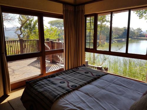 a bedroom with a bed in front of a large window at Kruger Park Lodge ITR01 3 Bedroom in Hazyview