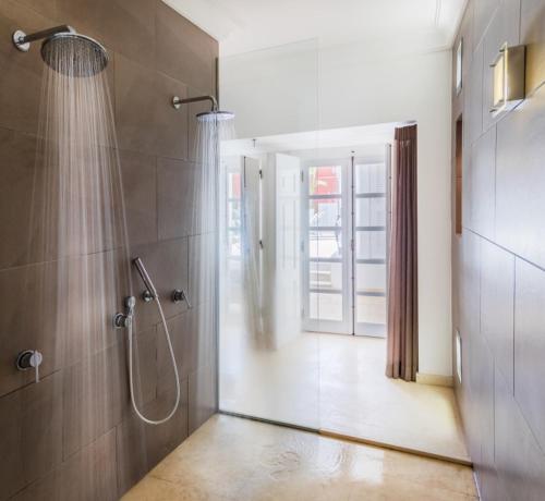 La salle de bains est pourvue d'une douche avec une porte en verre. dans l'établissement Villa Zawaia B&B, à Lagos
