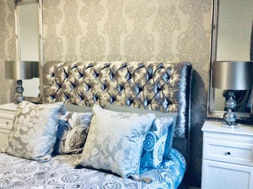 a bedroom with a bed with blue and white pillows at THE LION'S DEN ON ROYAL STREET in Gourock
