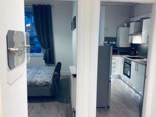 a kitchen with white cabinets and a table in a room at THE LION'S DEN ON ROYAL STREET in Gourock