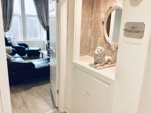a living room with a mirror and a lion statue at THE LION'S DEN ON ROYAL STREET in Gourock