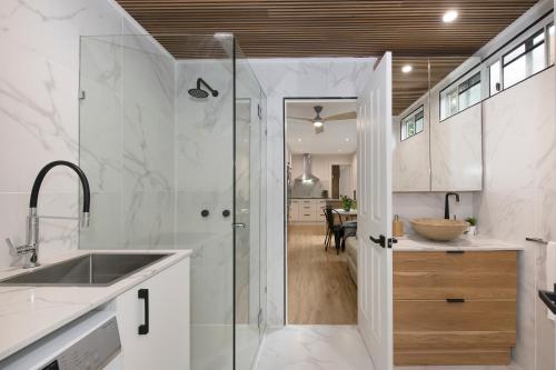 uma casa de banho com um chuveiro, um lavatório e uma cozinha em Cosy 2 bedroom home em Townsville