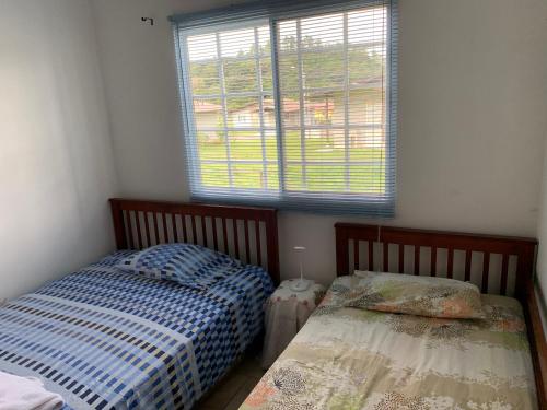 two beds in a small room with a window at Eucaliptos Bed and Breakfast in Volcán