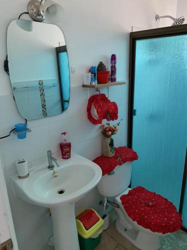 Un baño con lavabo, inodoro y espejo. en Eucaliptos Bed and Breakfast, en Volcán