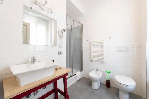 a white bathroom with a sink and a toilet at Guest House Al Conservatorio in Rome