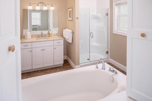 a white bathroom with a tub and a shower at Inn at Harbor Hill Marina in Niantic