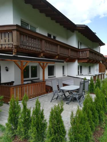 a patio with a table and chairs in front of a house at Appartementhaus Gleirscher in Neustift im Stubaital
