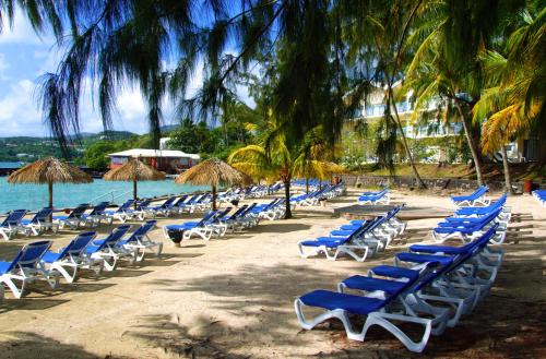 a bunch of chairs and umbrellas on a beach at Carayou Hotel & SPA in Les Trois-Îlets