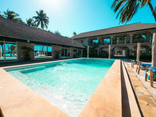 a swimming pool in front of a building at Paje Beach Apartments & Hotel in Paje