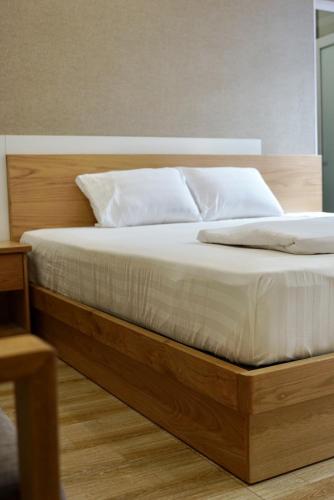 a bed with white sheets and pillows in a bedroom at Mui Tau Hotel Phan Ri Cua in Tuy Phong