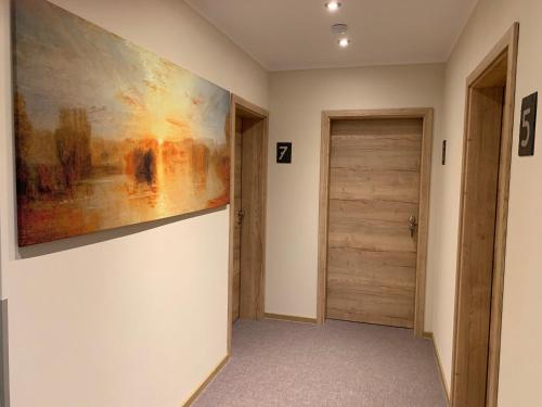 a hallway with a painting on the wall next to a door at Weinbergs Loge in Ernst