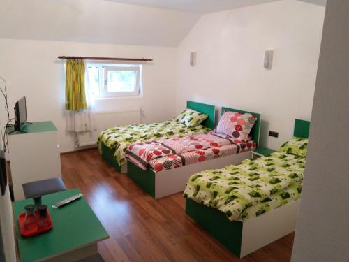 a room with two beds and a table and a table sidx sidx sidx at Casa MILOS SI FIUL in Băile Herculane