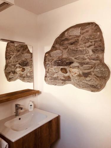 a bathroom with a sink and a stone wall at Casa Ruscada in Borgnone