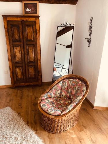 a wicker chair sitting in a room with a mirror at Casa Ruscada in Borgnone