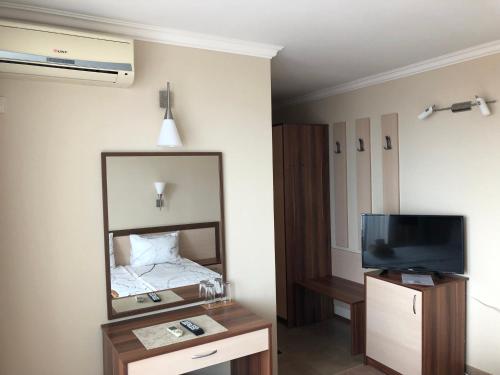 a hotel room with a mirror and a tv at Family Hotel Radiana in Sozopol