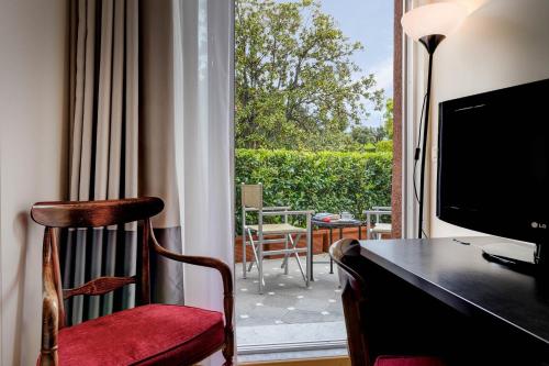 a room with a desk and a television and a balcony at Hotel Continental in Santa Margherita Ligure