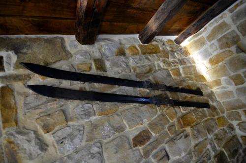 two knives sitting on top of a stone wall at El Pontón de Lanchares in Lanchares