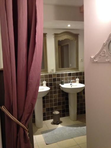 une salle de bain avec deux lavabos et un miroir dans l'établissement Montagne attitude, à Jausiers