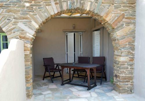 an archway with a table and chairs on a patio at Paesino in Kionia
