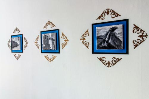 a group of framed pictures on a wall at Zythogite Appartement 6 personnes avec jardin, bbq in Tintigny