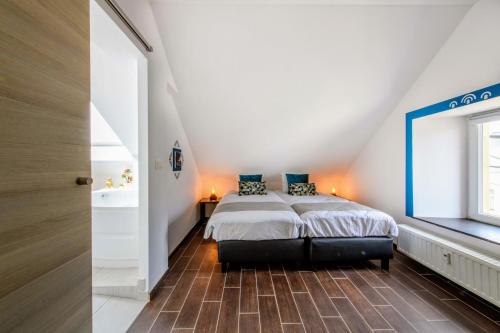 a bedroom with a bed in a attic at Zythogite Appartement 6 personnes avec jardin, bbq in Tintigny
