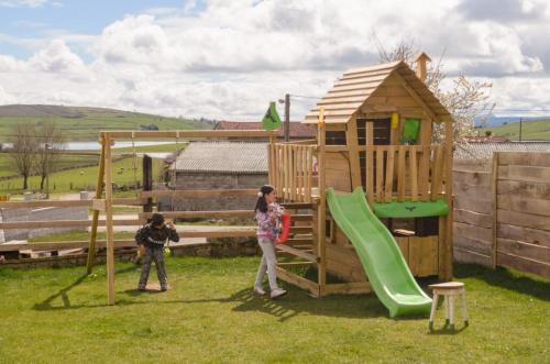 a woman and a child standing in front of a playground at El Pontón de Lanchares in Lanchares