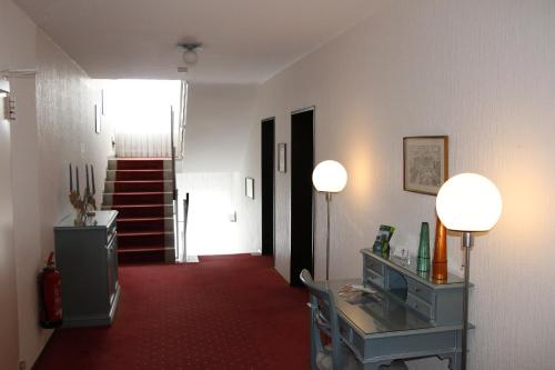 a hallway with two lamps and a red carpet at Bremer Schlüssel in Braunlage