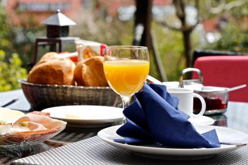 einen Tisch mit einem Glas Orangensaft und einem Korb Brot in der Unterkunft Bremer Schlüssel in Braunlage