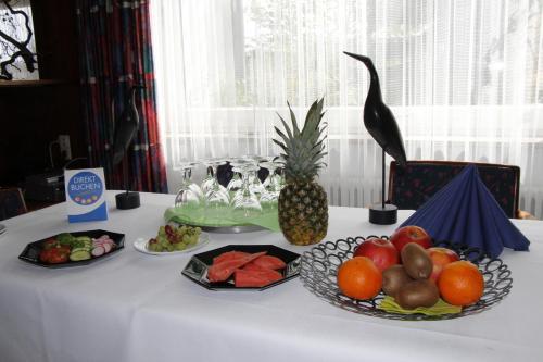 a table topped with plates of fruit and a pineapple at Bremer Schlüssel in Braunlage