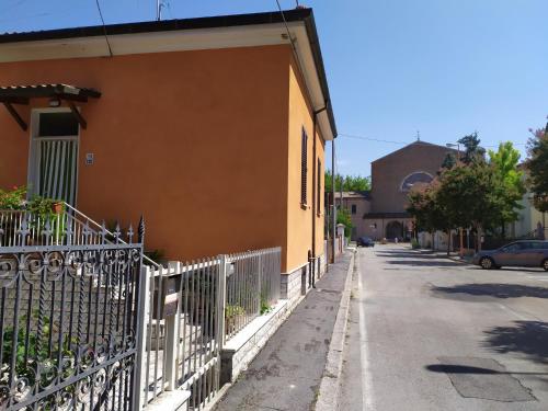 a fence on the side of a building next to a street at Casa L'Osservanza in Cesena
