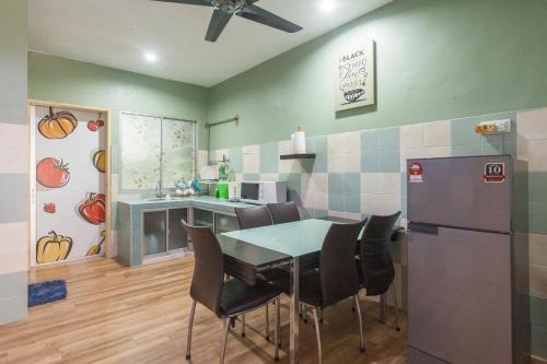 eine Küche mit Tisch und Stühlen und einem Kühlschrank in der Unterkunft Gunung View Homestay 10 to 12 pax near Sunway Tambun in Ipoh
